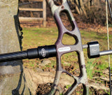 Titanium alloy quick disconnect archery accessory attached to a camouflage bow, enhancing bow control and reducing noise