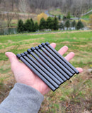 Hand holding multiple titanium cable guard rods for compound bows, ideal for improved bow control and reduced noise