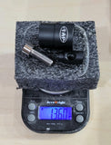 TAP-DOA ULTRA-Light stabilizers for archery displayed on a scale showing 136 grams, featuring a sleek black finish