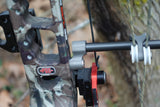 PSE Titanium cable guard coupler installed on a camouflaged PSE bow for enhanced performance and reduced vibration